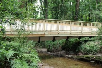 Una sección de 15 metros de una pala de turbina desgastada, transportada en camión desde un parque eólico de Colorado, fue utilizada para construir un puente sobre un arroyo en un parque de Atlanta | FM Avenida